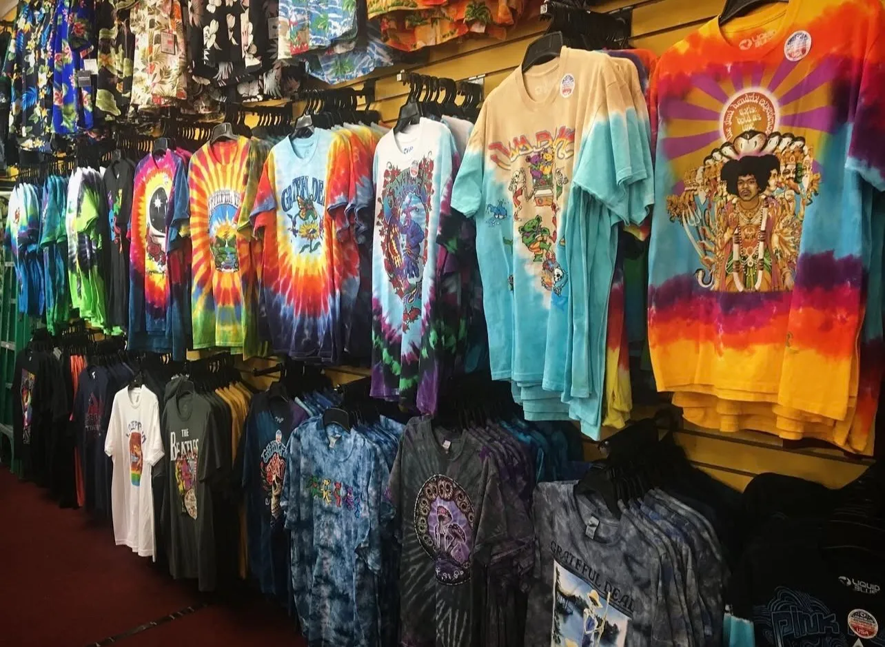 A wall of colorful tie-dye and graphic T-shirts inside the shop.